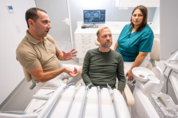 Dr. Fuchs erklärt einem Patienten die Behandlung im Behandlungszimmer